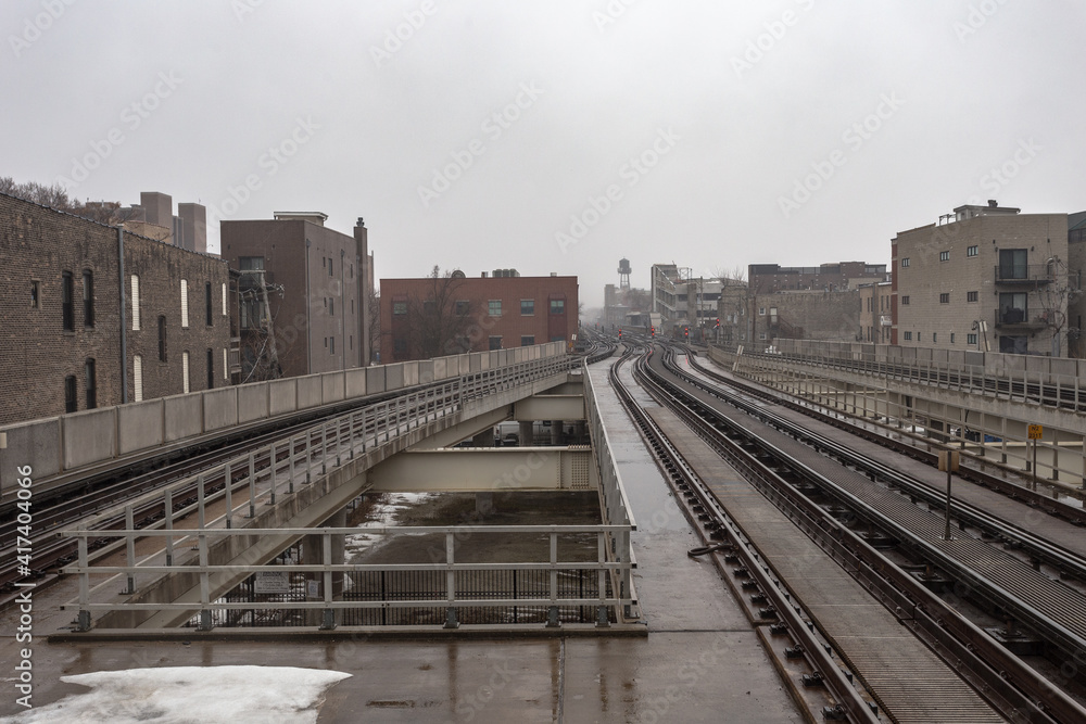 Wet empty elevated subway tracks on overcast day in urban Chicago