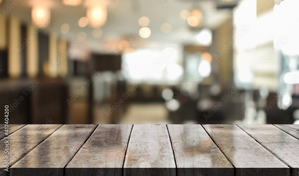 Empty wooden table top with lights bokeh on blur restaurant background. Empty wooden table top with lights bokeh on blur restaurant background.