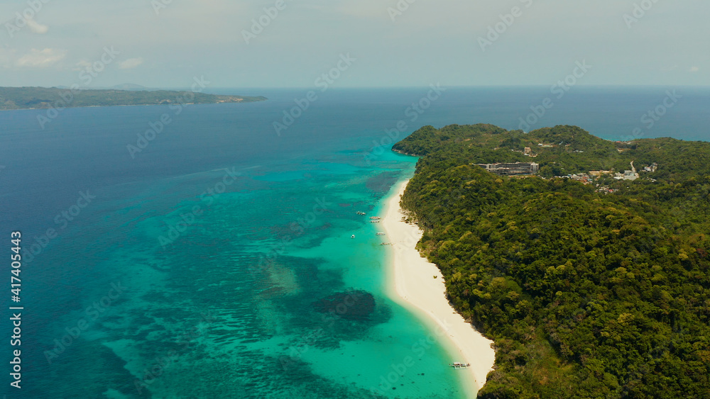Tropical white sand beach, near the blue lagoon and corall reef from above, Boracay, Philippines. Sandy beach with tourists. Summer and travel vacation concept.