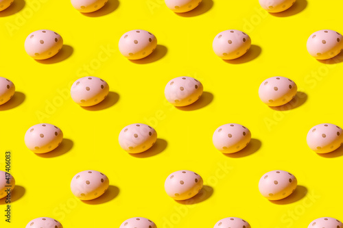 Easter seamless pattern. Pink painted egg on a yellow background. Creative packaging design in the concept of minimalism.