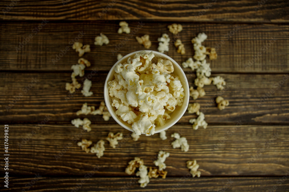 popcorn in a bowl, top view, on a wooden background popcorn in a bowl, top view, on a wooden background