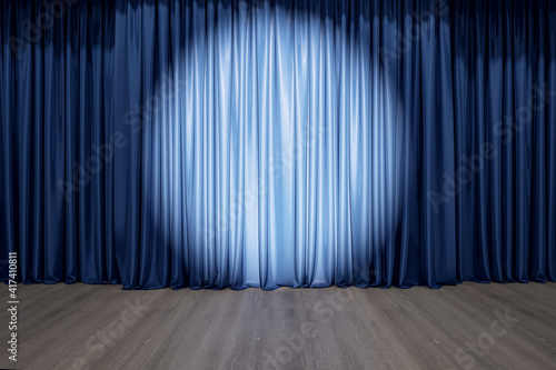 Round spotlight on blue curtain on the stage with wooden floor