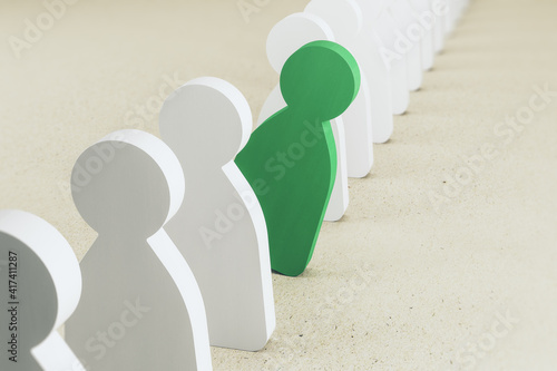 Thinking outside the box concept with green human wooden figure falls out of line of white figures