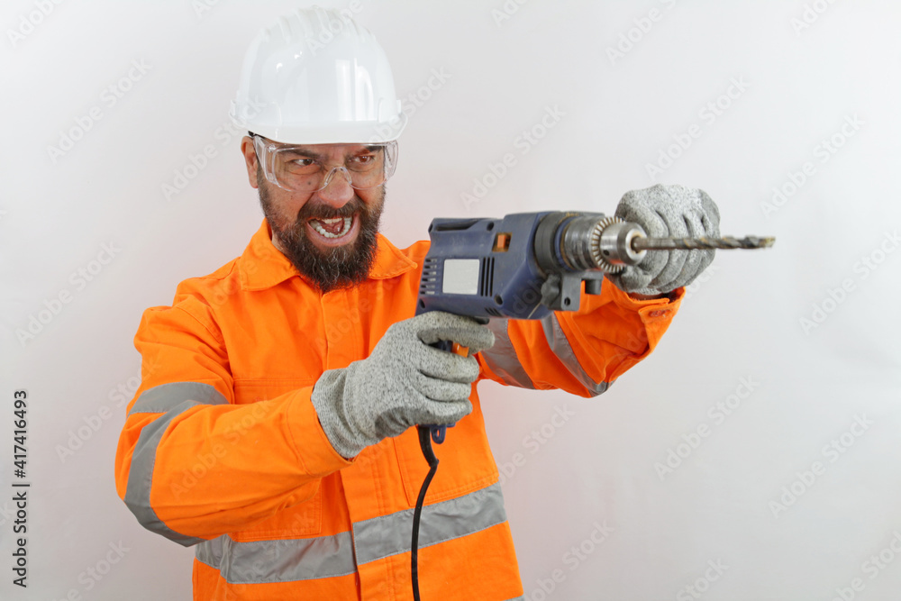 Bearded Builder wearing hardhat and reflecting jacket screaming shouting anger rage with drill tool. Bearded Builder wearing hardhat and reflecting jacket screaming shouting anger rage with drill tool.
