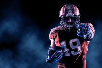 Football Player with a orange uniform coming out of a stadium tunnel.