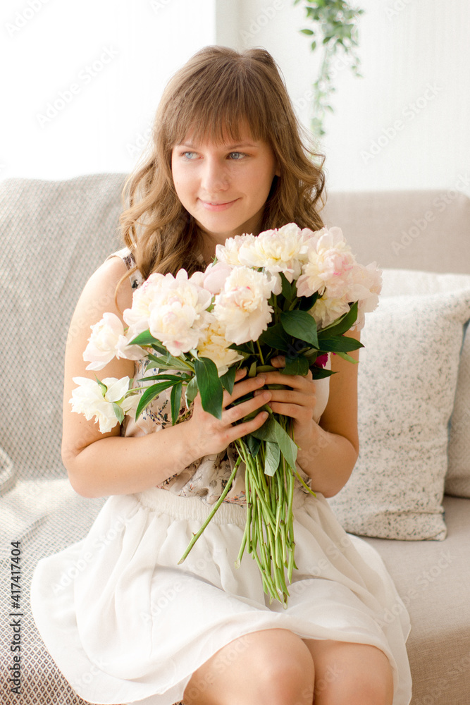 Portrait of a young girl with bouquet of flowers at home