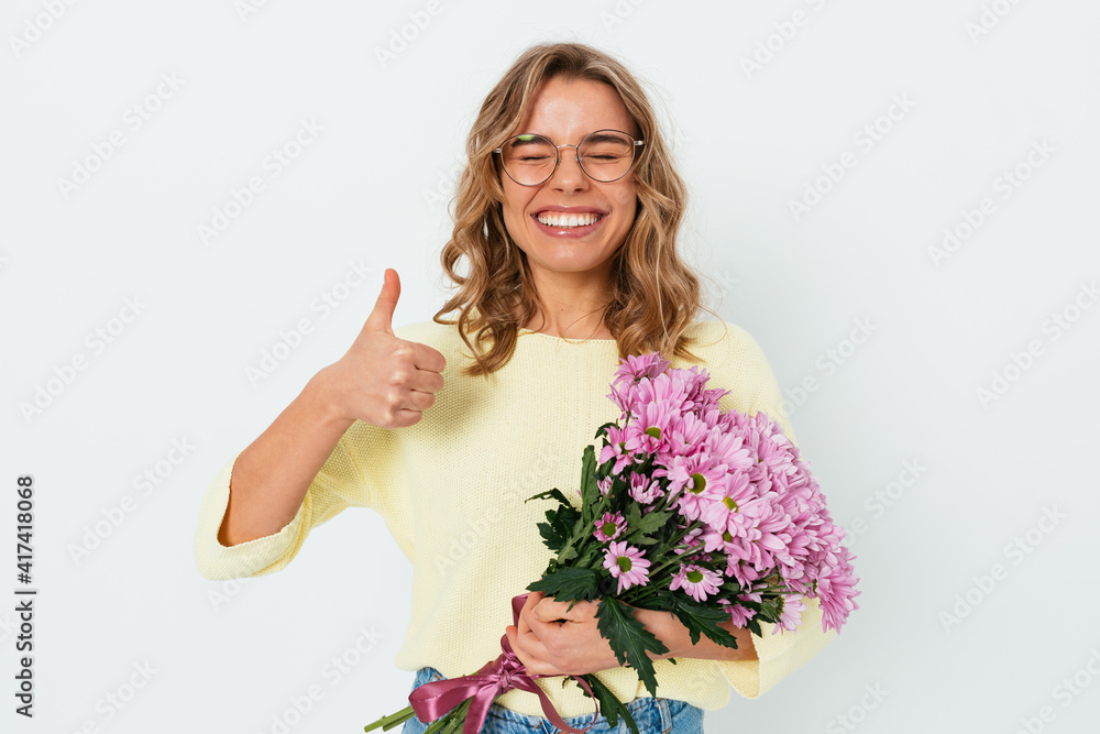 Cheerful young woman wearing glasses with eyes closed holding bouquet fresh flowers Cheerful young woman wearing glasses with eyes closed holding bouquet fresh flowers