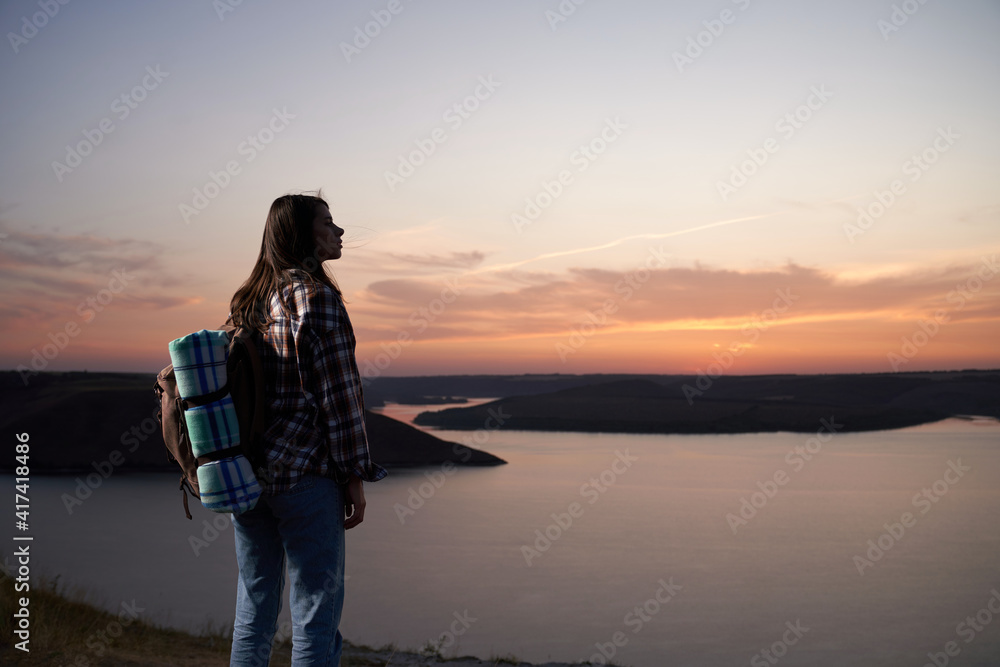 Attractive woman hiking during amazing sunset