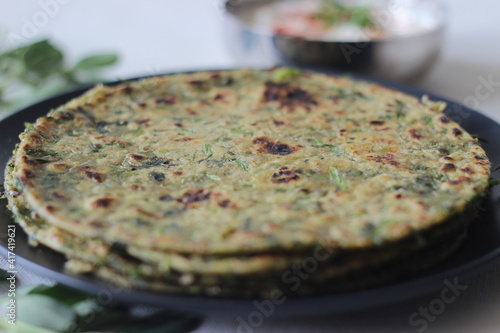 Whole wheat methi thepla rolls with paneer capsicum filling and a bowl of masala curd.