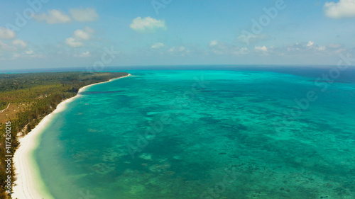 Tropical island with sandy beach by atoll with coral reef and blue sea, aerial view. Bugsuk Island with sandy beach. Summer and travel vacation concept.