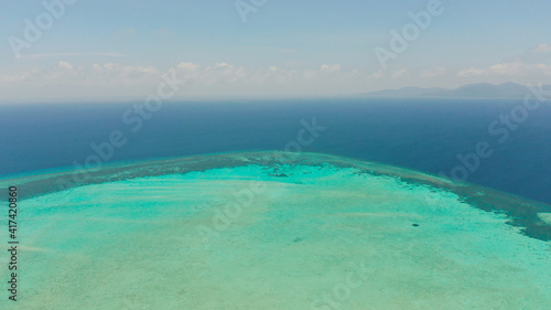 Tropical coral atoll with turquoise water against the sky with clouds top view. Summer and travel vacation concept. Balabac, Palawan, Philippines