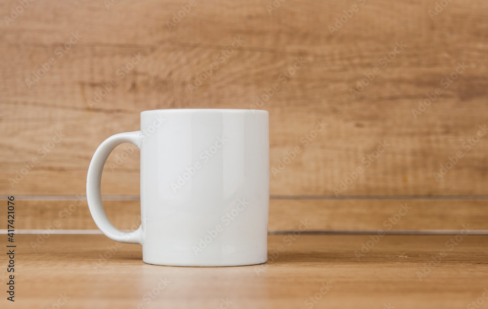 White mug on the wooden table White mug on the wooden table