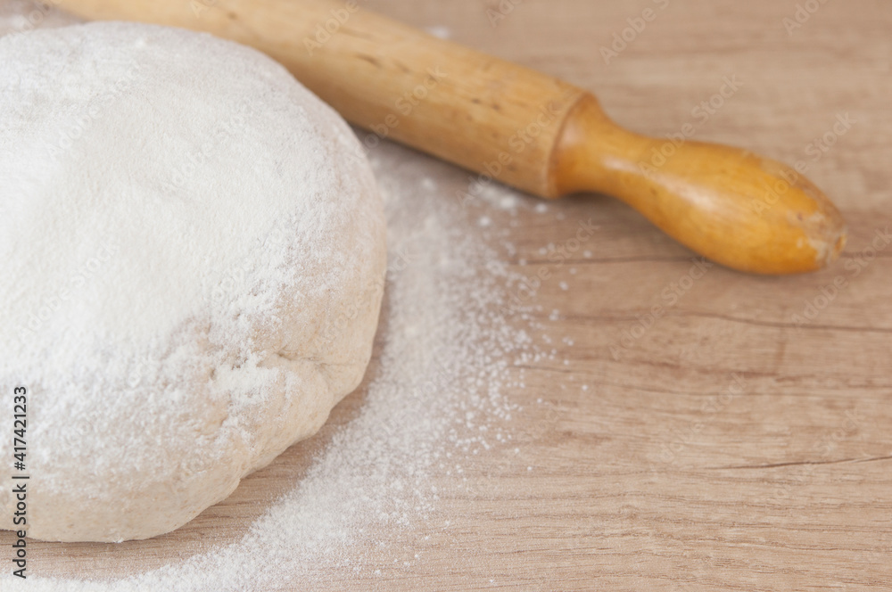 homemade pizza dough with rolling pin on the wooden table homemade pizza dough with rolling pin on the wooden table