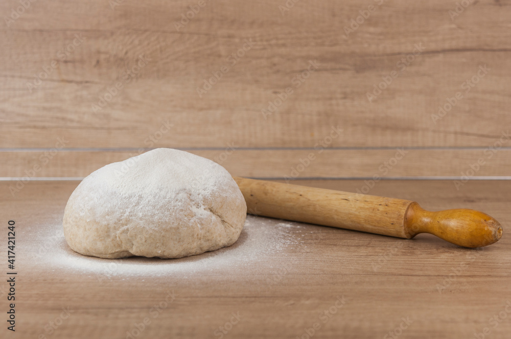 homemade pizza dough with rolling pin on the wooden table homemade pizza dough with rolling pin on the wooden table