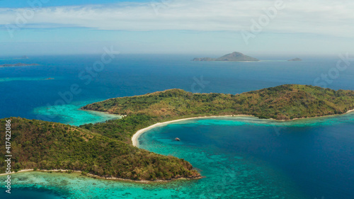 tropical island with blue lagoon, coral reef and sandy beach. Ditaytayan, Palawan, Philippines. Islands of the Malayan archipelago with turquoise lagoons.