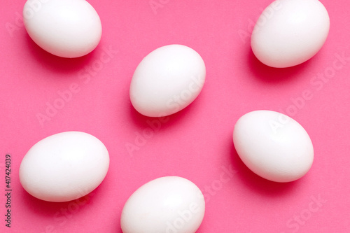 white chicken eggs on a pink background. Easter