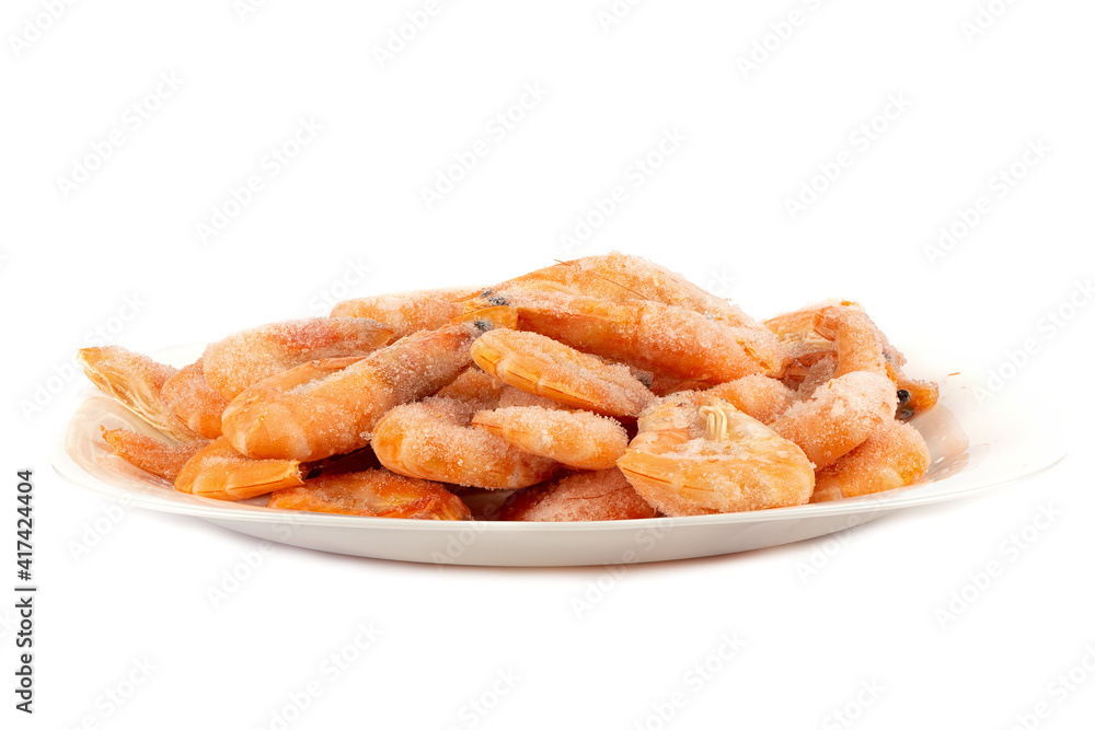 Frozen shrimps in a white plate over a white background. Frozen shrimps in a white plate over a white background.
