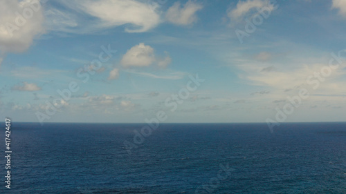 Blue ocean with waves and sky with clouds, seascape top view. Water cloud horizon background. Blue sea water with waves against sky.