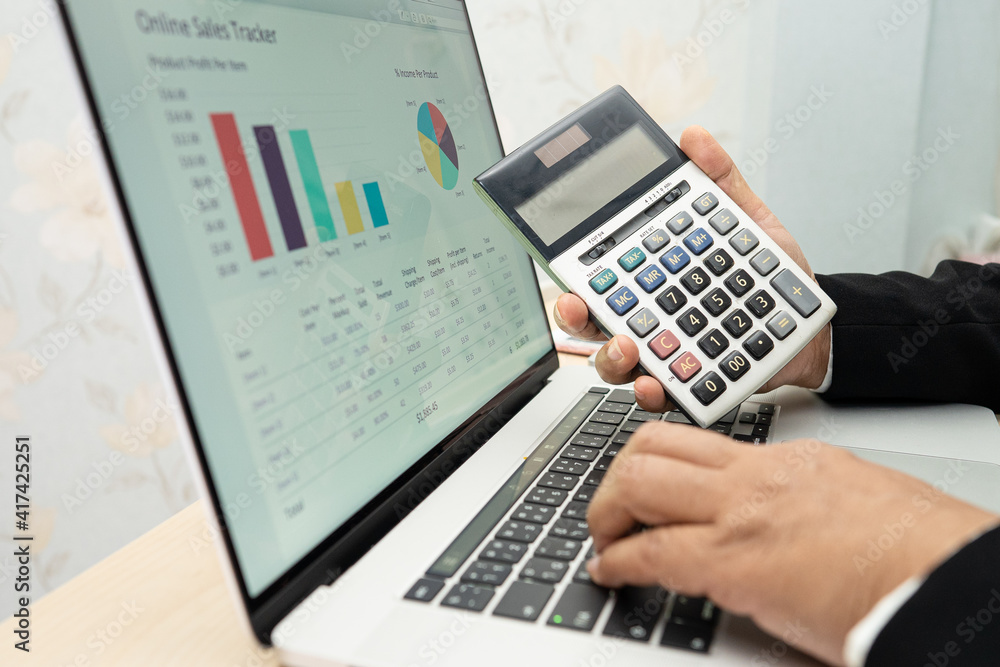 Asian accountant working and analyzing financial reports project accounting with chart graph and calculator in modern office, finance and business concept. Asian accountant working and analyzing financial reports project accounting with chart graph and calculator in modern office, finance and business concept.