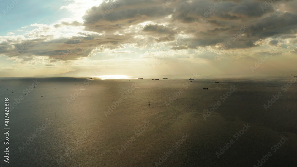 Dramatic sunset over Manila Bay with ships and cargo ships, top view. Summer and travel vacation concept