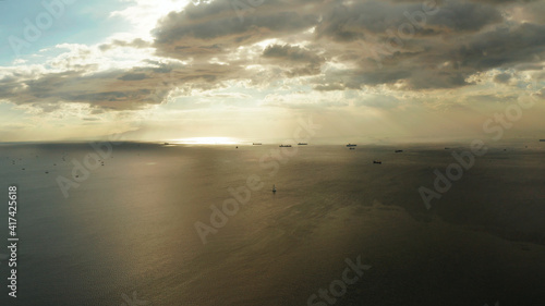 Dramatic sunset over Manila Bay with ships and cargo ships  top view. Summer and travel vacation concept