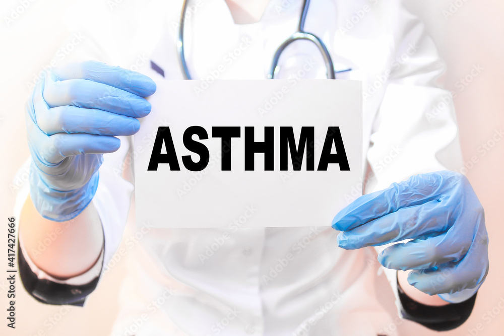 The doctor's blue - gloved hands show the word ASTHMA - . a gloved hand on a white background. Medical concept. the medicine The doctor's blue - gloved hands show the word ASTHMA - . a gloved hand on a white background. Medical concept. the medicine