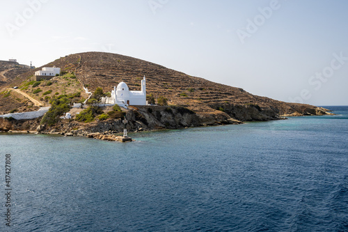 Sea bay and Greek church on the cliff, symbol of Ios island. Cyclades, Greece.