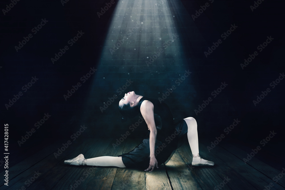Young woman dancing ballet under a bright light