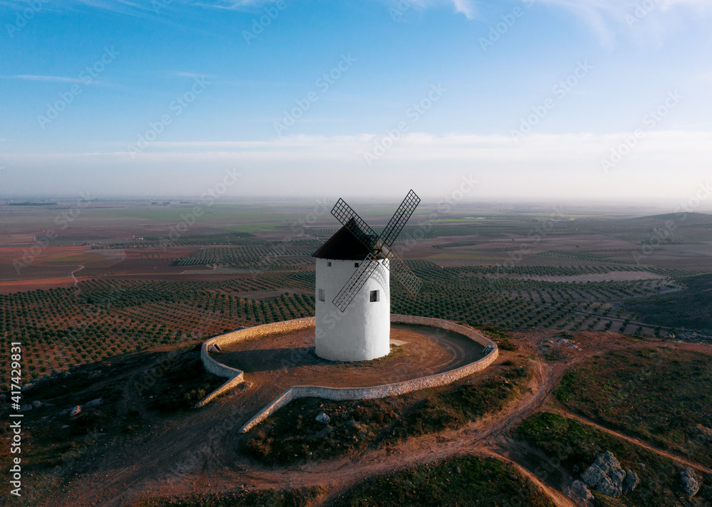 Fototapeta premium windmill on the mountain in european fields castile la mancha don quixote evening light air plane