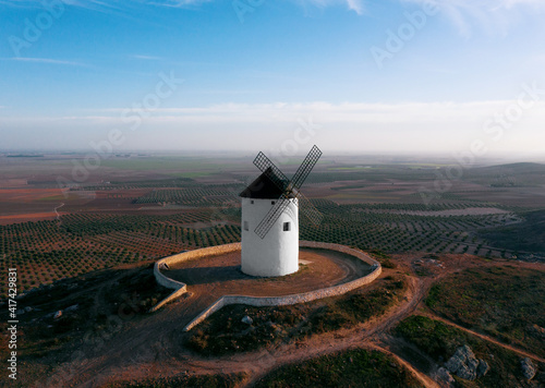 windmill on the mountain in european fields castile la mancha don quixote evening light air plane