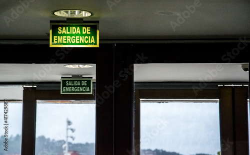 Letrero de salida de emergencia en la puerta de cristal de un museo de arte moderno
