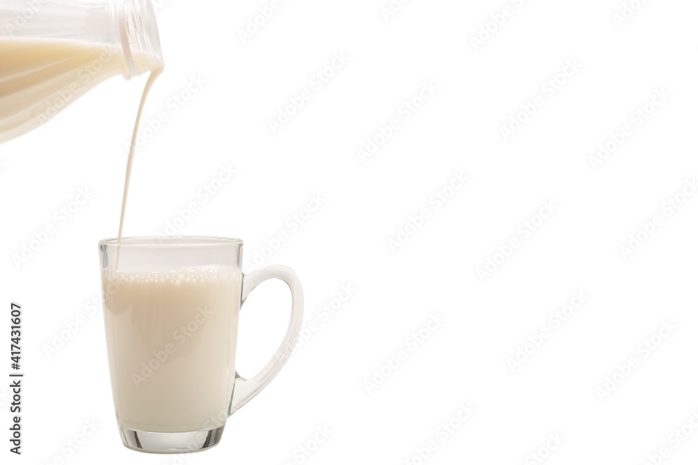 Milk is being poured from a bottle into a cup. Milk is being poured from a bottle into a cup.