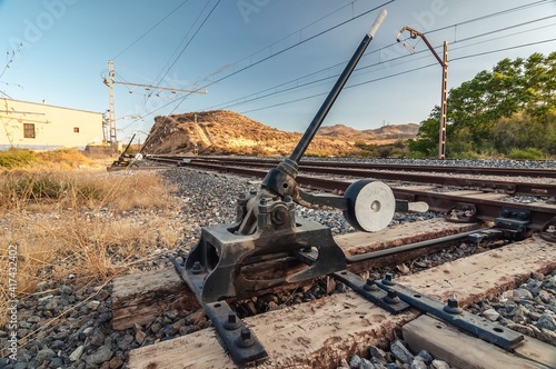 interruptor ferroviario de cambio de agujas en vía de ferrocarril en la vía férrea con un cruce entre ellas photo