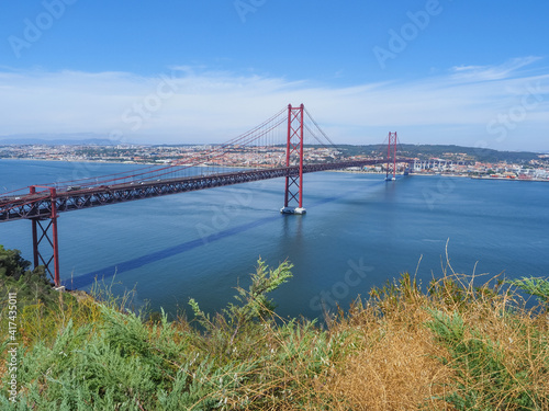 Famous Ponte 25 de Abril Bridge. Over 2km-long, red Golden Gate-style, beautiful suspension bridge links Lisbon with Almada. Panoramic view from Christ the King Square. 