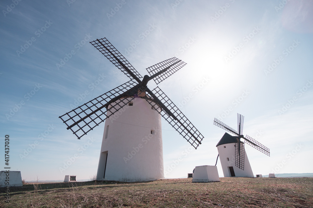 two old white windmills from casilla la mancha don quixote in spain in europe blue sky