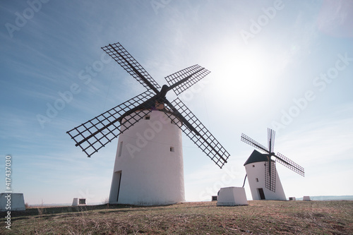 two old white windmills from casilla la mancha don quixote in spain in europe blue sky