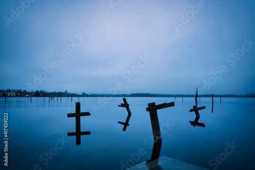 Reflection of objects in a blue lake and a cloudy sky