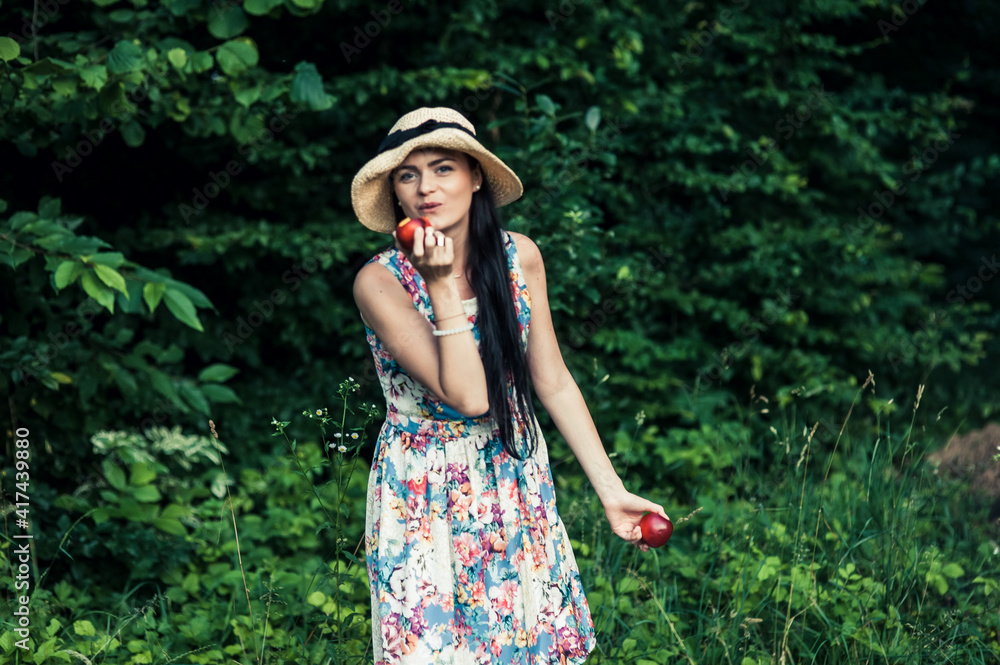 Girl on a picnic eats fruit.