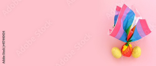 Colorful Easter eggs on a pink background in a the style of minimalism. with place for text. Easter background with lights. layout concept for lgbt