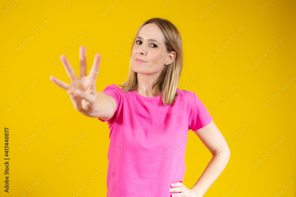 Young smiling woman over isolated yellow background counting four with fingers Young smiling woman over isolated yellow background counting four with fingers