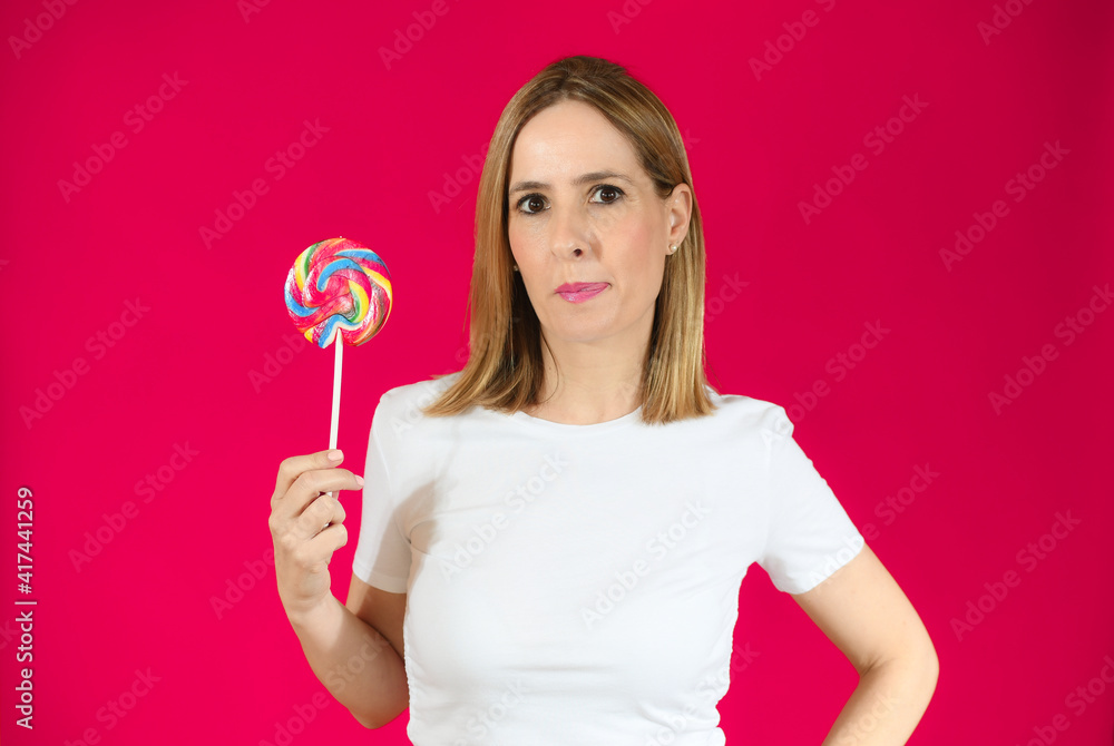Young woman holding a big lollipop over isolated over pink background. Young woman holding a big lollipop over isolated over pink background.