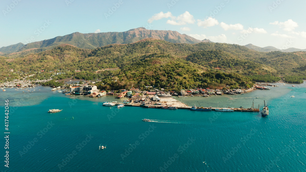 Ferry port in the city of Coron, on the island Busuanga, Philippines. Passenger and cargo port with ships. Ferries transport vehicles and passengers in port