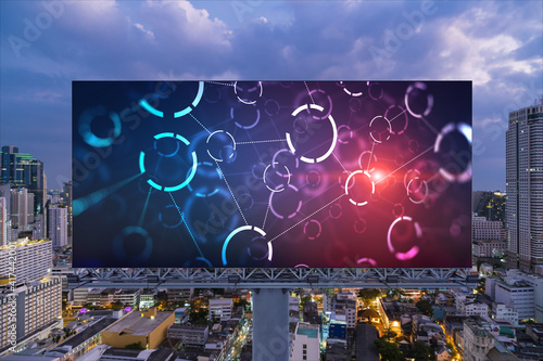 Information flow hologram on road billboard, night panorama city view of Bangkok. The largest technological center in Southeast Asia. The concept of programming science.