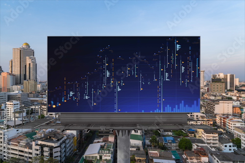 Glowing FOREX graph hologram on billboard, aerial panoramic cityscape of Bangkok at sunset. Stock and bond trading in Southeast Asia. The concept of fund management.