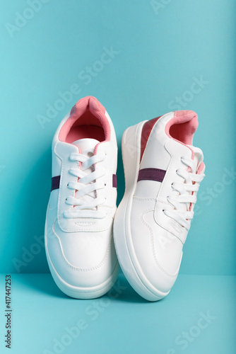 Blue sport sneakers shoes on the blue background. Fitness background. Healthy lifestyle concept. Trendy front view.