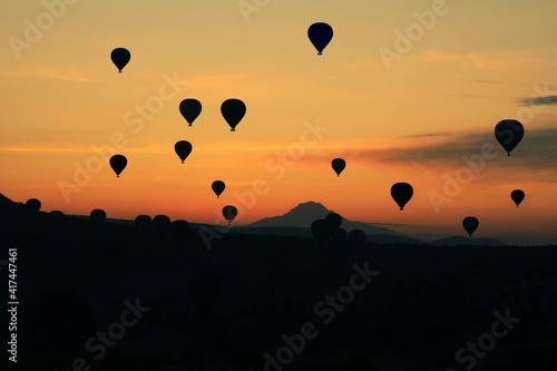 silhouette air balloons flying over the valley at Cappadocia. Hot air balloons are traditional touristic attraction in Cappadocia.