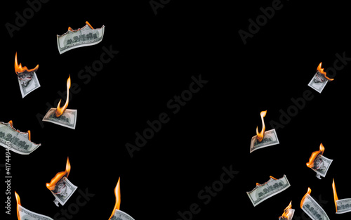 Several 100 dollar bills, falling down, burn on a black background. The concept of bankruptcy, default, depreciation, devaluation, wastefulness and waste of money. Copy space, isolated.