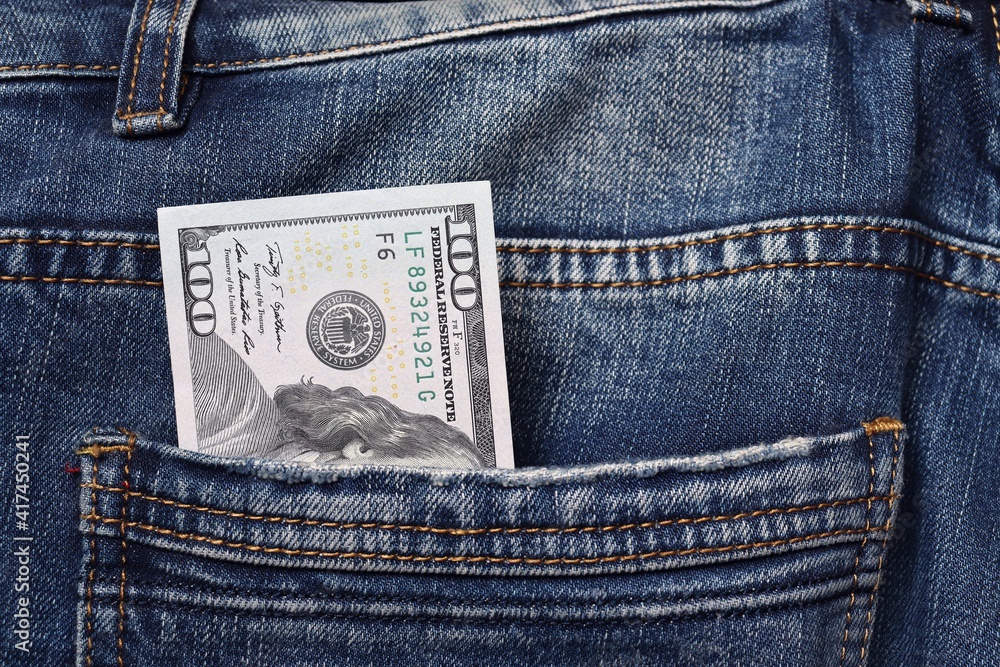 Close-up of a $ 100 bill in a jeans pocket Close-up of a $ 100 bill in a jeans pocket