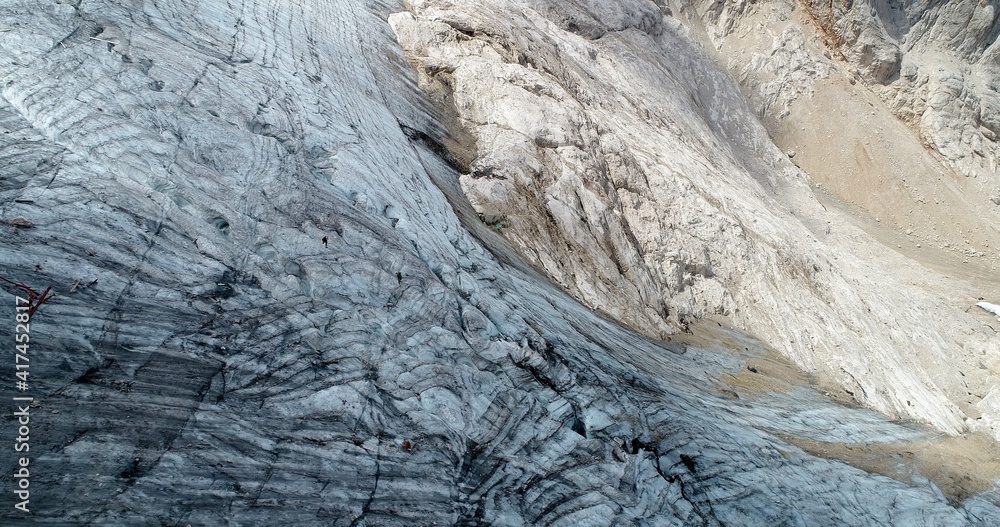 Fototapeta premium The Marmolada glacier in summer: Aerial view of the last and the only glacier of the Dolomites, UNESCO heritage, near the town of Canazei - August 2018 - Evidence of global warming and melting glacier