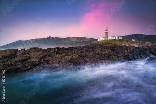 The beautiful lighthouse of Lariño (also known as Punta Insua) during a sunset with striking colors. Carnota, Galicia, Spain